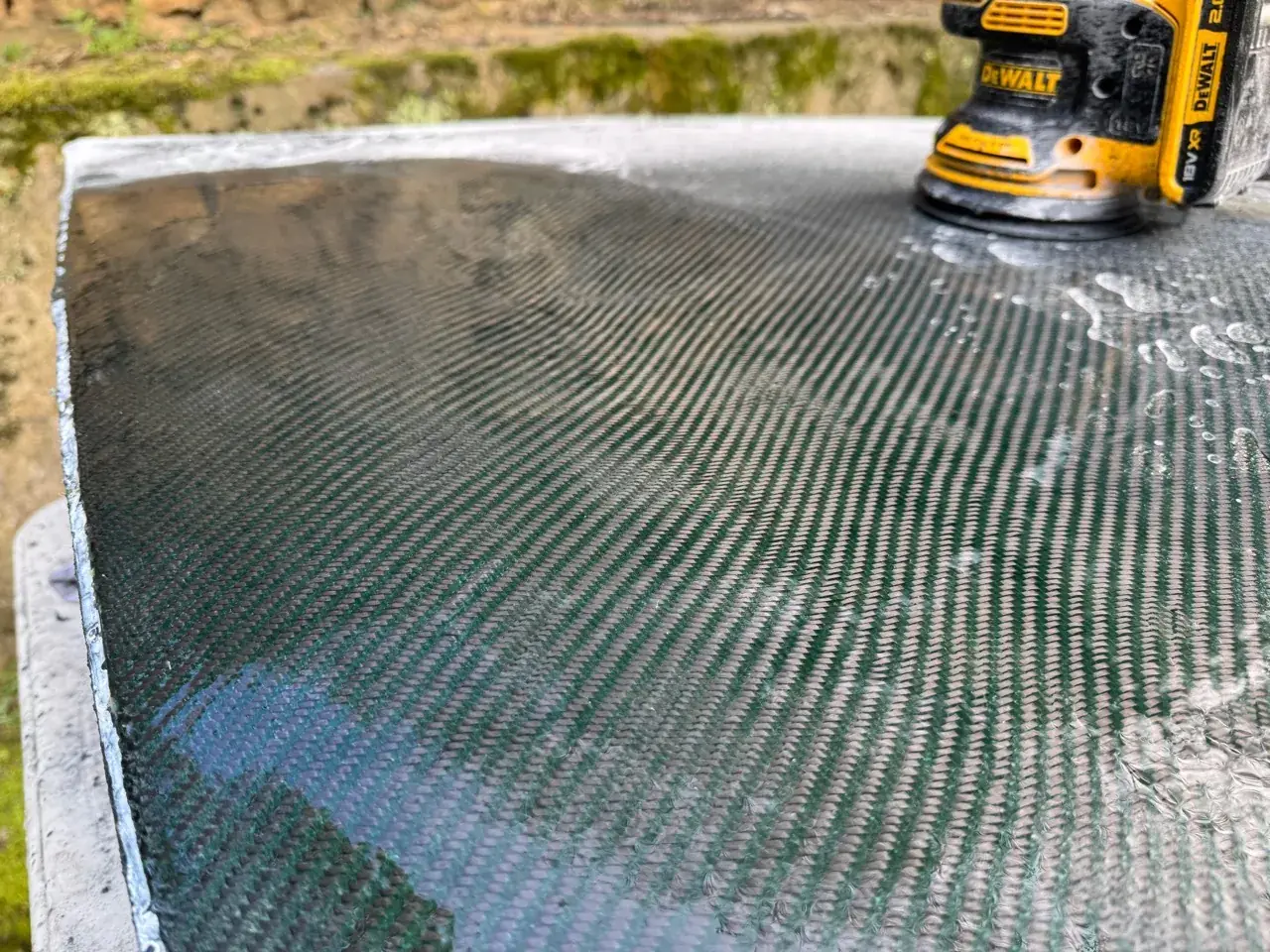 Carbon fibre bonnet being surface-finished with an orbital sander