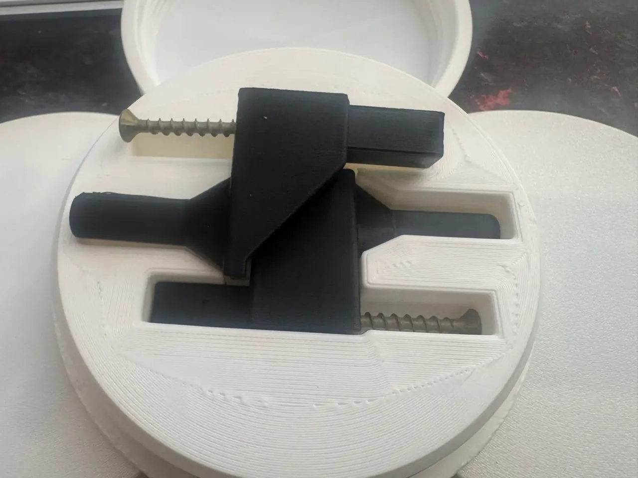 Black parcel shelf hinge components after being pushed out of the opened white packaging