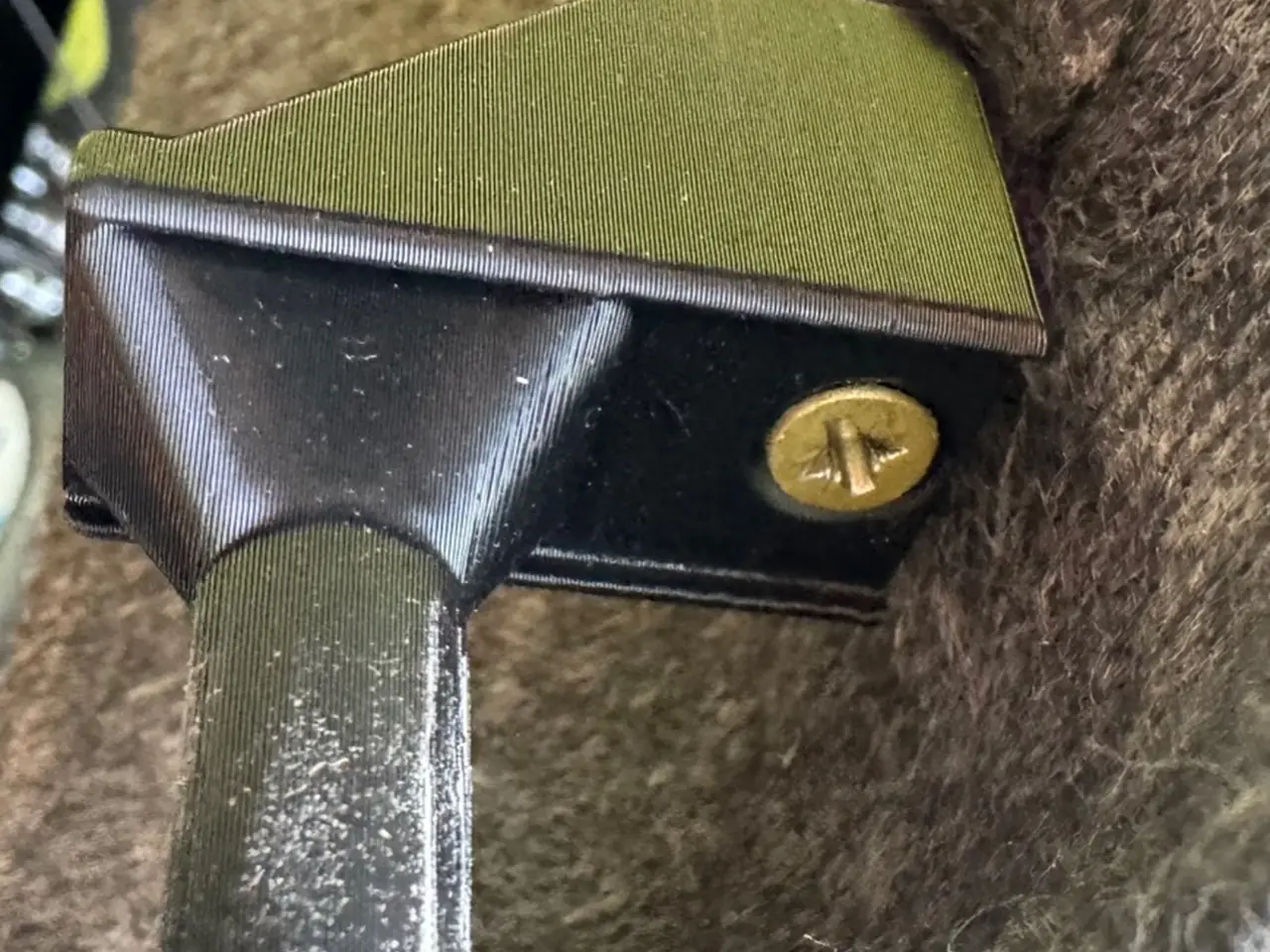 Close view of the installed parcel shelf hinge showing its clamping section and fastener